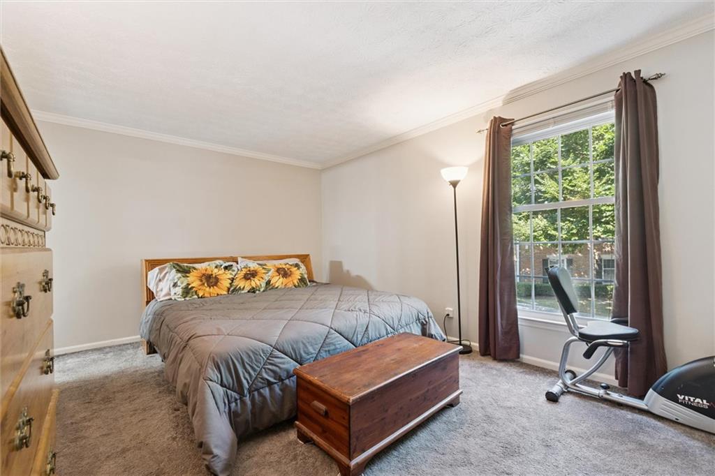 6700 Roswell Road, Unit 31B Atlanta, GA 30328 - Photo 20 of 32 a bedroom with a bed and a dresser next to a window