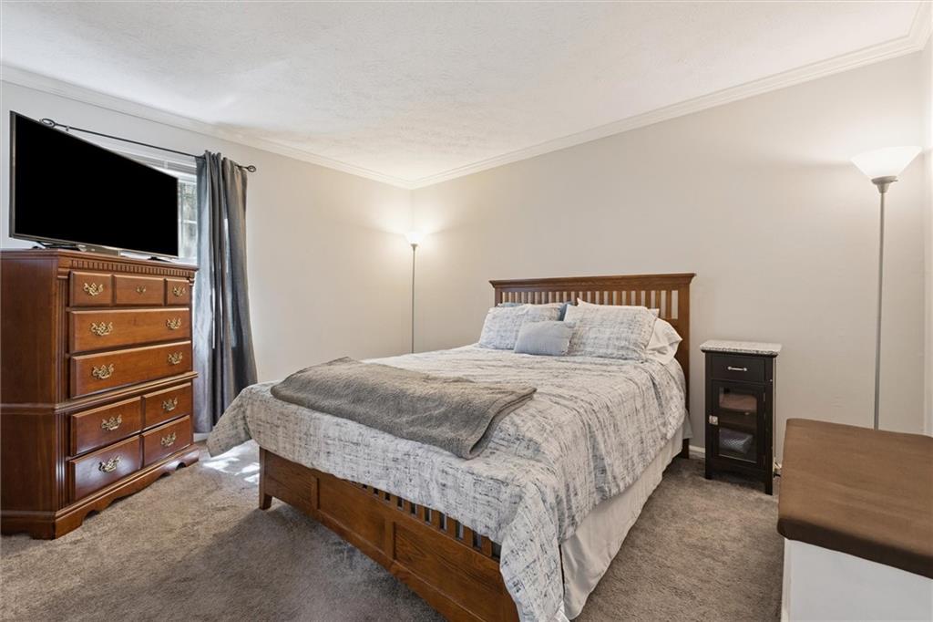 6700 Roswell Road, Unit 31B Atlanta, GA 30328 - Photo 21 of 32 a bedroom with a bed and a flat tv screen on wall