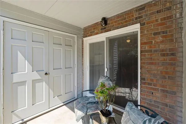 a view of a door and chair and table in front of house
