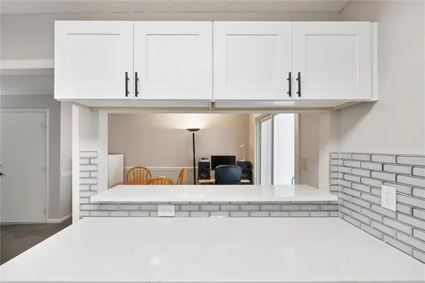 a view of a kitchen with white cabinets and a stove