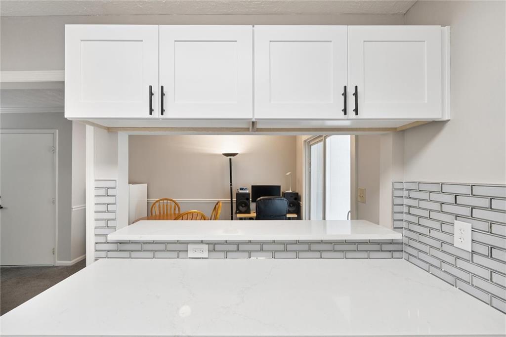6700 Roswell Road, Unit 31B Atlanta, GA 30328 - Photo 4 of 32 a view of a kitchen with white cabinets and a stove