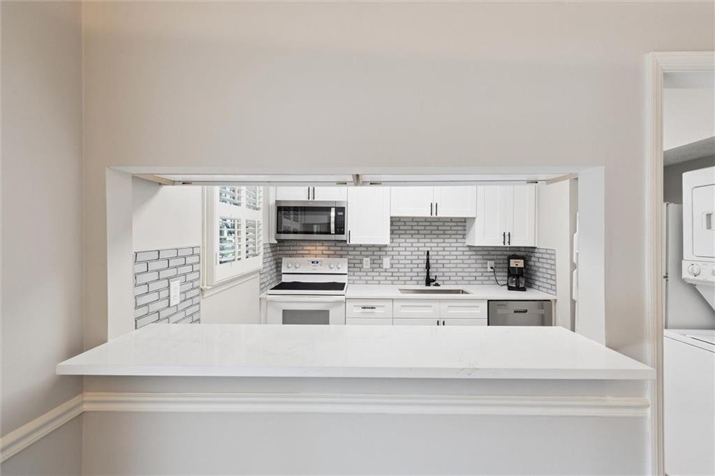 6700 Roswell Road, Unit 31B Atlanta, GA 30328 - Photo 6 of 32 a kitchen with stainless steel appliances a white stove top oven and white cabinets