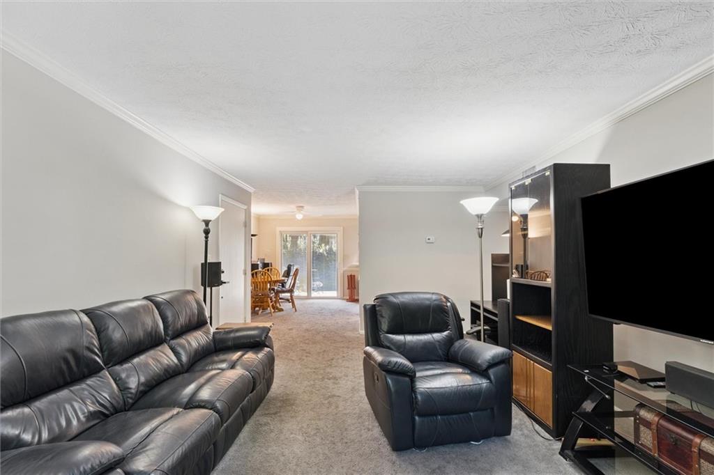 6700 Roswell Road, Unit 31B Atlanta, GA 30328 - Photo 9 of 32 a living room with furniture and a flat screen tv