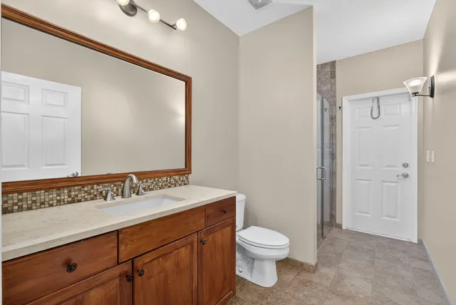a bathroom with a sink a toilet and a mirror