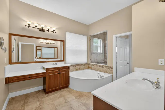 a bathroom with a tub sink and mirror