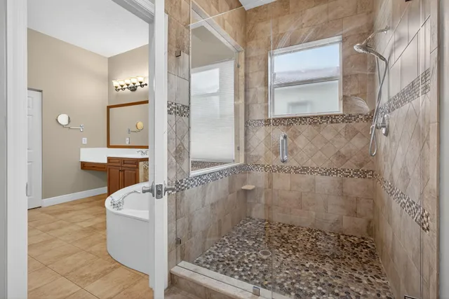 a bathroom with a glass shower door and a window