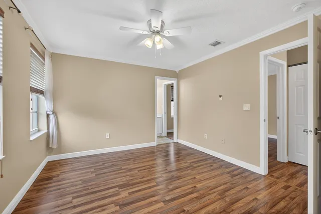 a view of an empty room with window and wooden floor