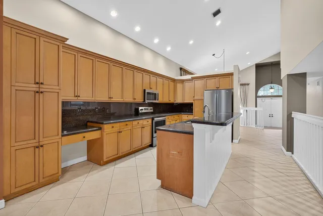 a kitchen with stainless steel appliances granite countertop a refrigerator and a stove top oven