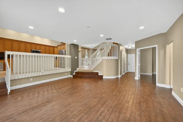 a view of a livingroom with wooden floor and staircase