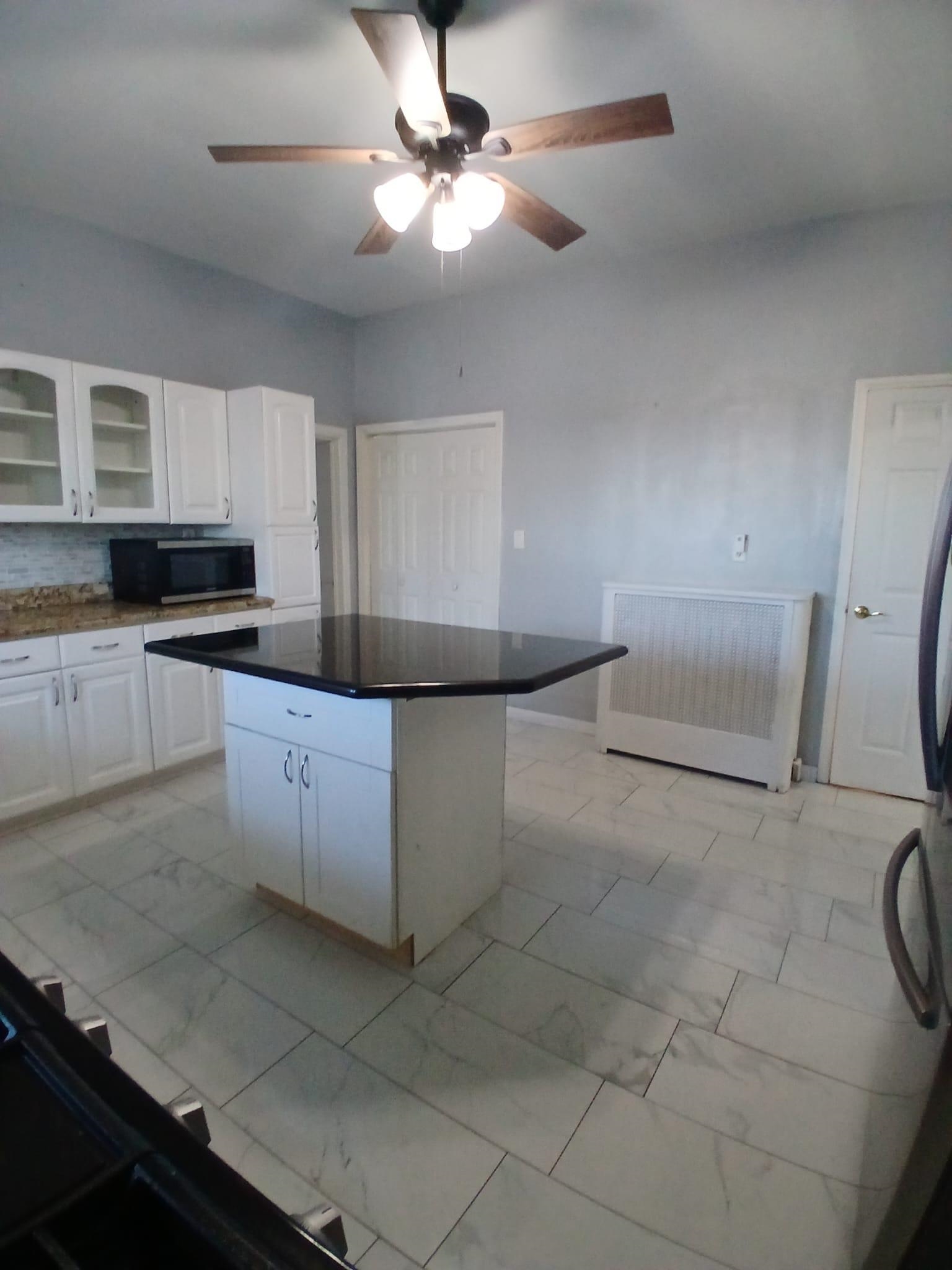 1212 89th Street North Bergen, NJ 07047 - Photo 16 of 41 a kitchen with granite countertop a sink a stove top oven and cabinets