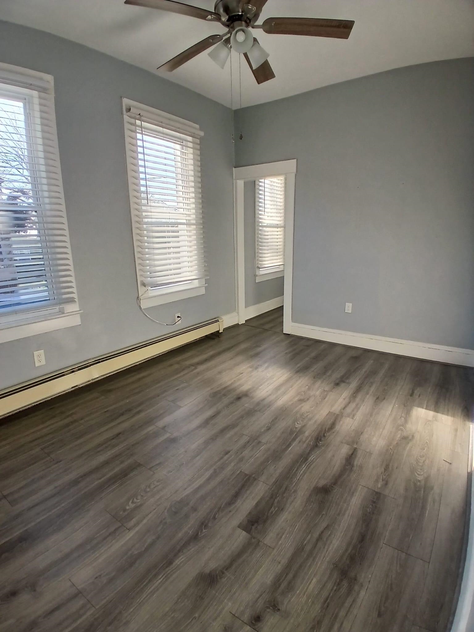 1212 89th Street North Bergen, NJ 07047 - Photo 18 of 41 a view of an empty room with wooden floor and a window