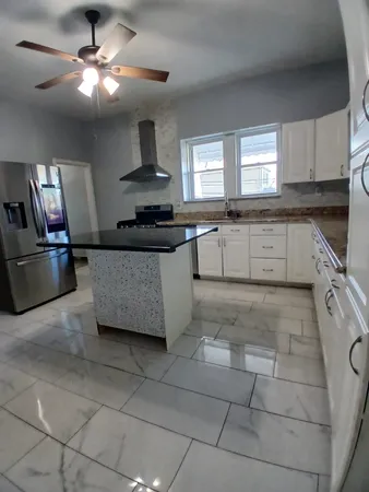 a kitchen with granite countertop a refrigerator and a sink