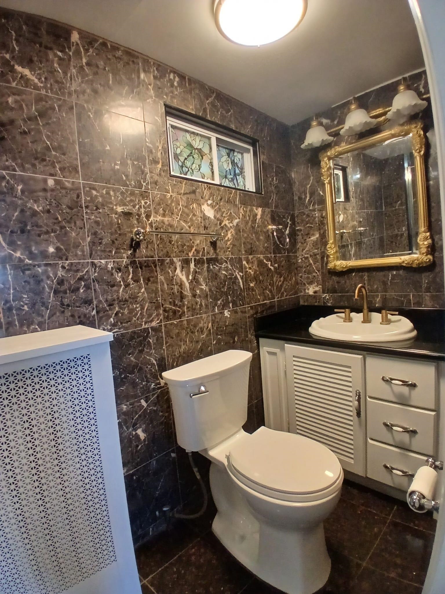 1212 89th Street North Bergen, NJ 07047 - Photo 33 of 41 a bathroom with a toilet a sink a mirror and a shower