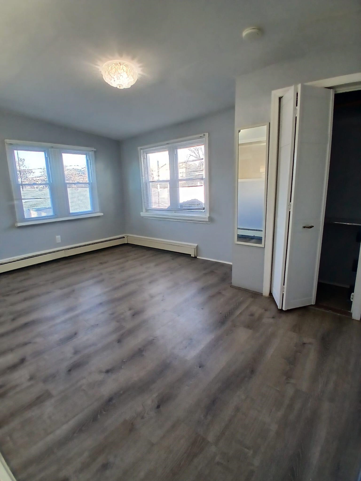1212 89th Street North Bergen, NJ 07047 - Photo 37 of 41 an empty room with wooden floor and windows