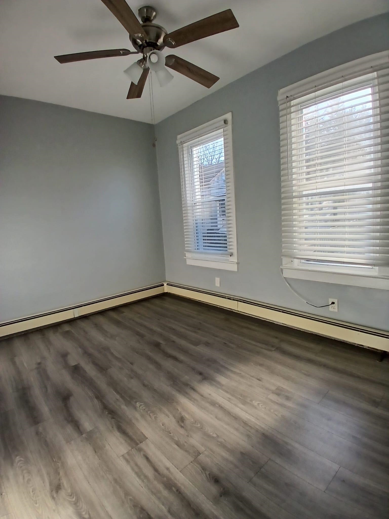 1212 89th Street North Bergen, NJ 07047 - Photo 39 of 41 an empty room with wooden floor and windows
