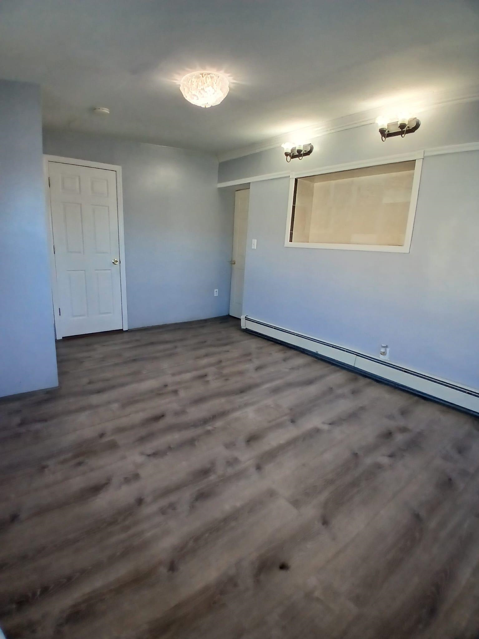 1212 89th Street North Bergen, NJ 07047 - Photo 40 of 41 an empty room with wooden floor mirror and windows