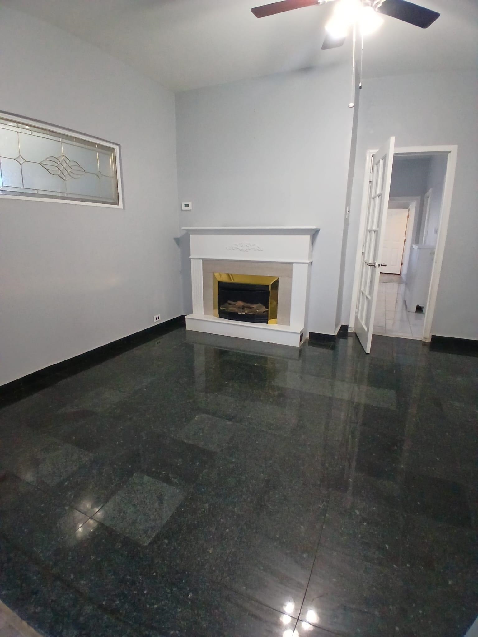 1212 89th Street North Bergen, NJ 07047 - Photo 4 of 41 a view of an empty room with wooden floor fireplace and a window