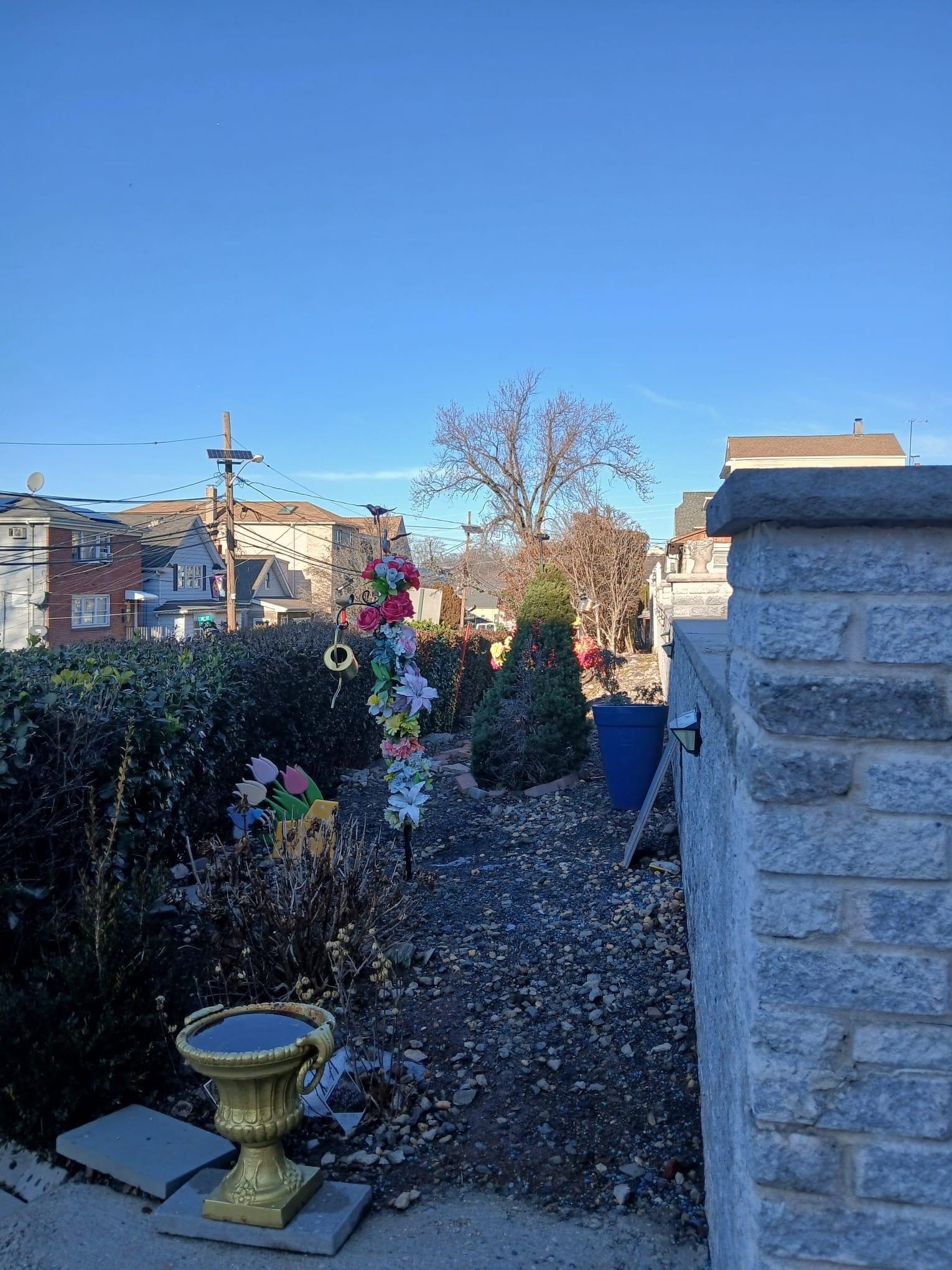 1212 89th Street North Bergen, NJ 07047 - Photo 10 of 41 a view of a fire pit with flower plants and wooden fence