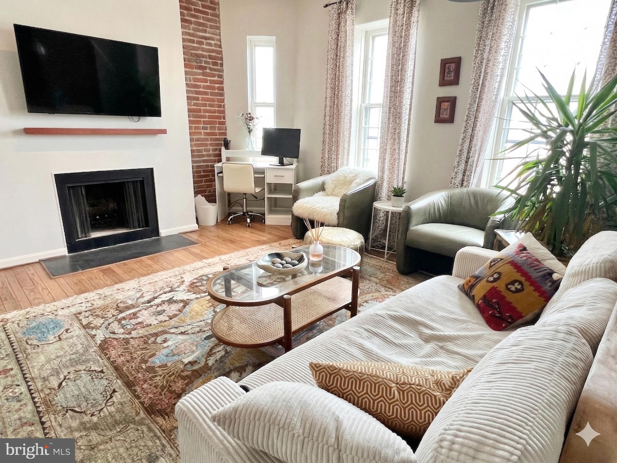 1718 Corcoran Street Northwest, Unit 45 Washington, DC 20009 - Photo 2 of 13 a living room with furniture and a flat screen tv