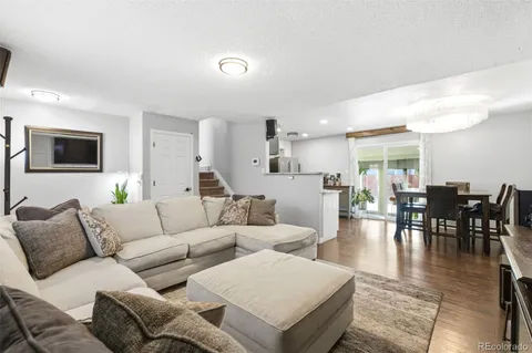 a living room with furniture wooden floor and a flat screen tv