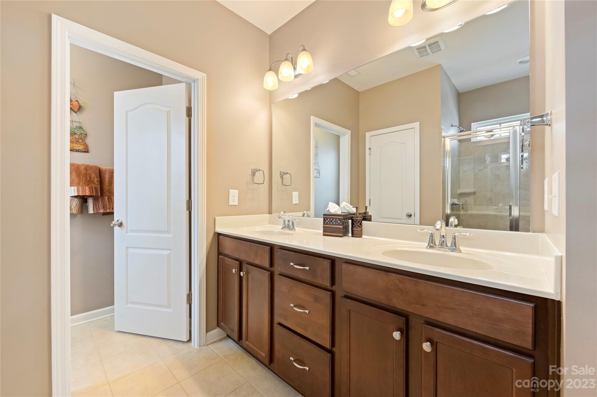 4087 Perth Road Indian Land, SC 29707 - Photo 25 of 46 a bathroom with a double vanity sink a large mirror and a shower