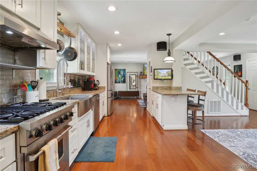 7101 Conifer Road Richmond, VA 23237 - Photo 22 of 50 a kitchen with stainless steel appliances granite countertop a stove and a wooden floors
