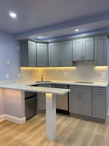 a view of an empty room with cabinet and a sink