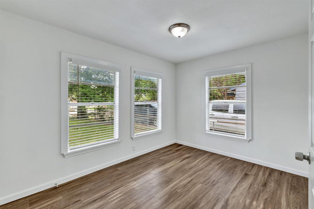 613 Cheyenne Road Dallas, TX 75217 - Photo 17 of 28 Room featuring wood-finish flooring, white walls, and three windows with blinds