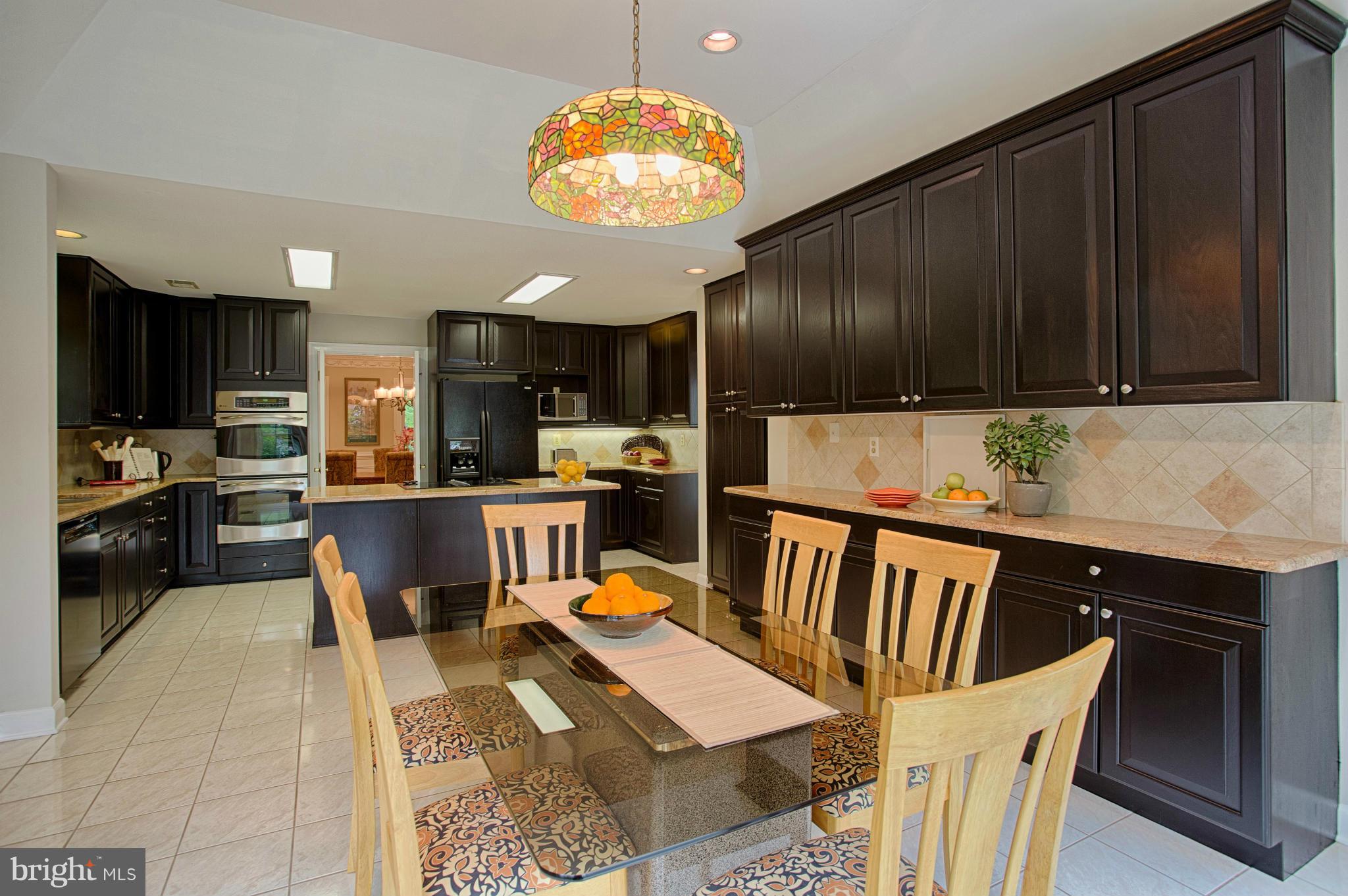 11311 Fieldstone Lane Reston, VA 20191 - Photo 6 of 30 a kitchen with stainless steel appliances granite countertop a stove top oven a sink dishwasher and cabinets with wooden floor