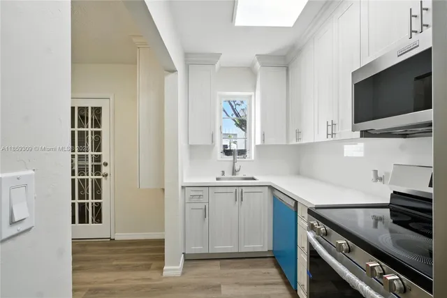 a kitchen with stainless steel appliances a stove microwave and sink