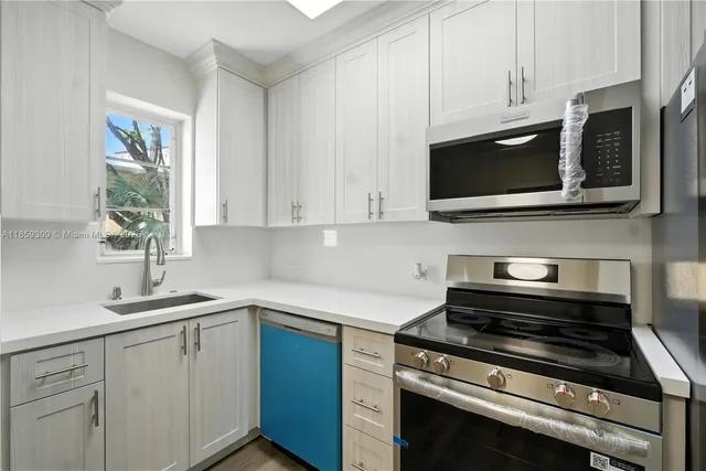 a kitchen with cabinets stainless steel appliances a sink and a window