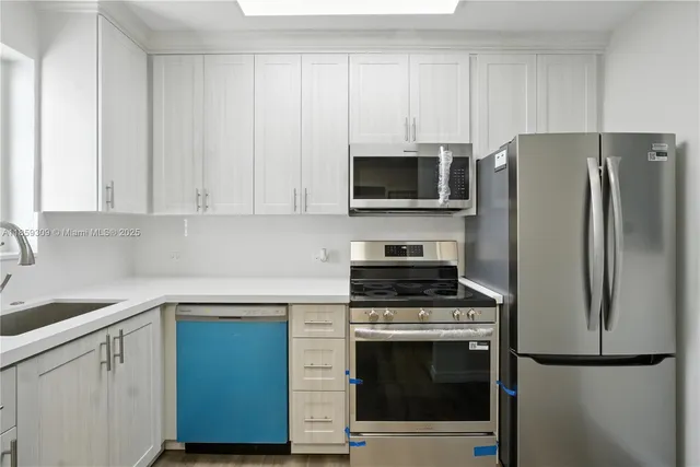 a kitchen with cabinets stainless steel appliances and a sink