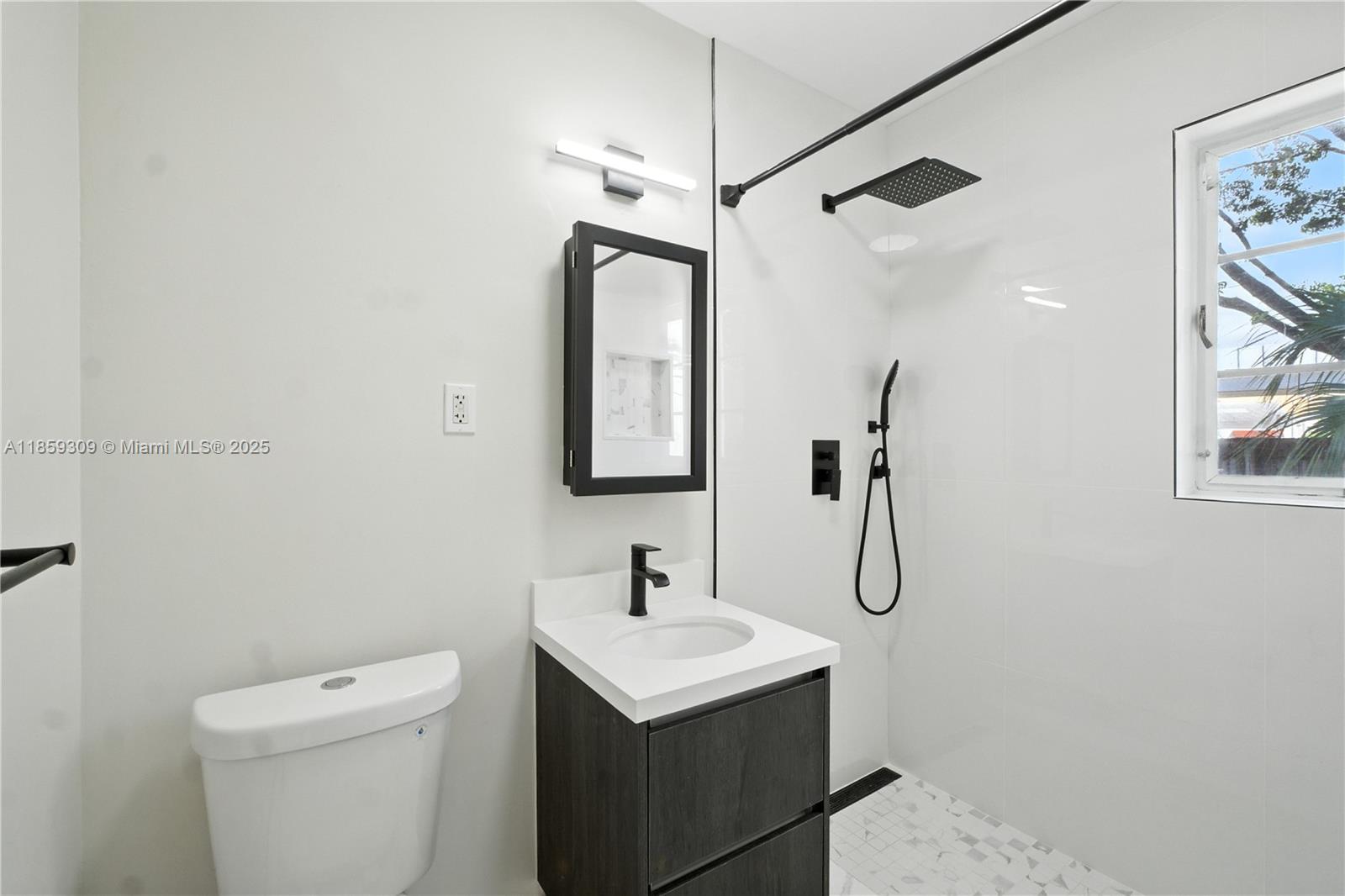 2545 Southwest 27th Lane Miami, FL 33133 - Photo 14 of 26 a bathroom with a sink a toilet and a mirror