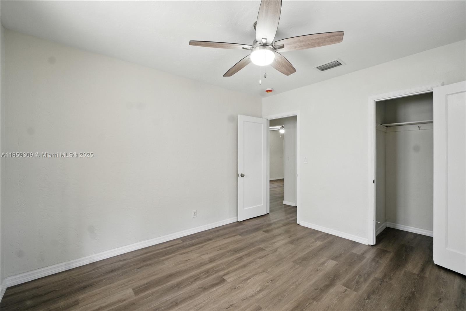 2545 Southwest 27th Lane Miami, FL 33133 - Photo 17 of 26 an empty room with wooden floor and ceiling fan