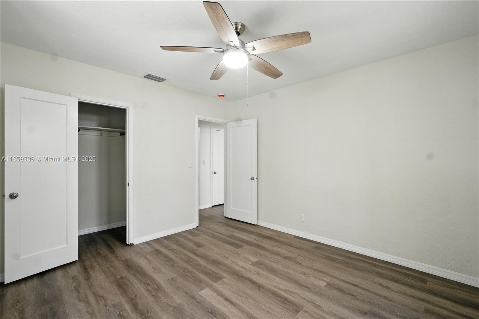 2545 Southwest 27th Lane Miami, FL 33133 - Photo 18 of 26 an empty room with wooden floor and ceiling fan