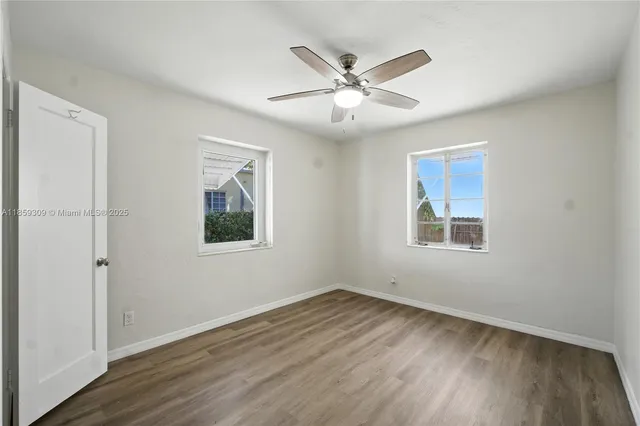 a view of a big room with wooden floor closet and windows