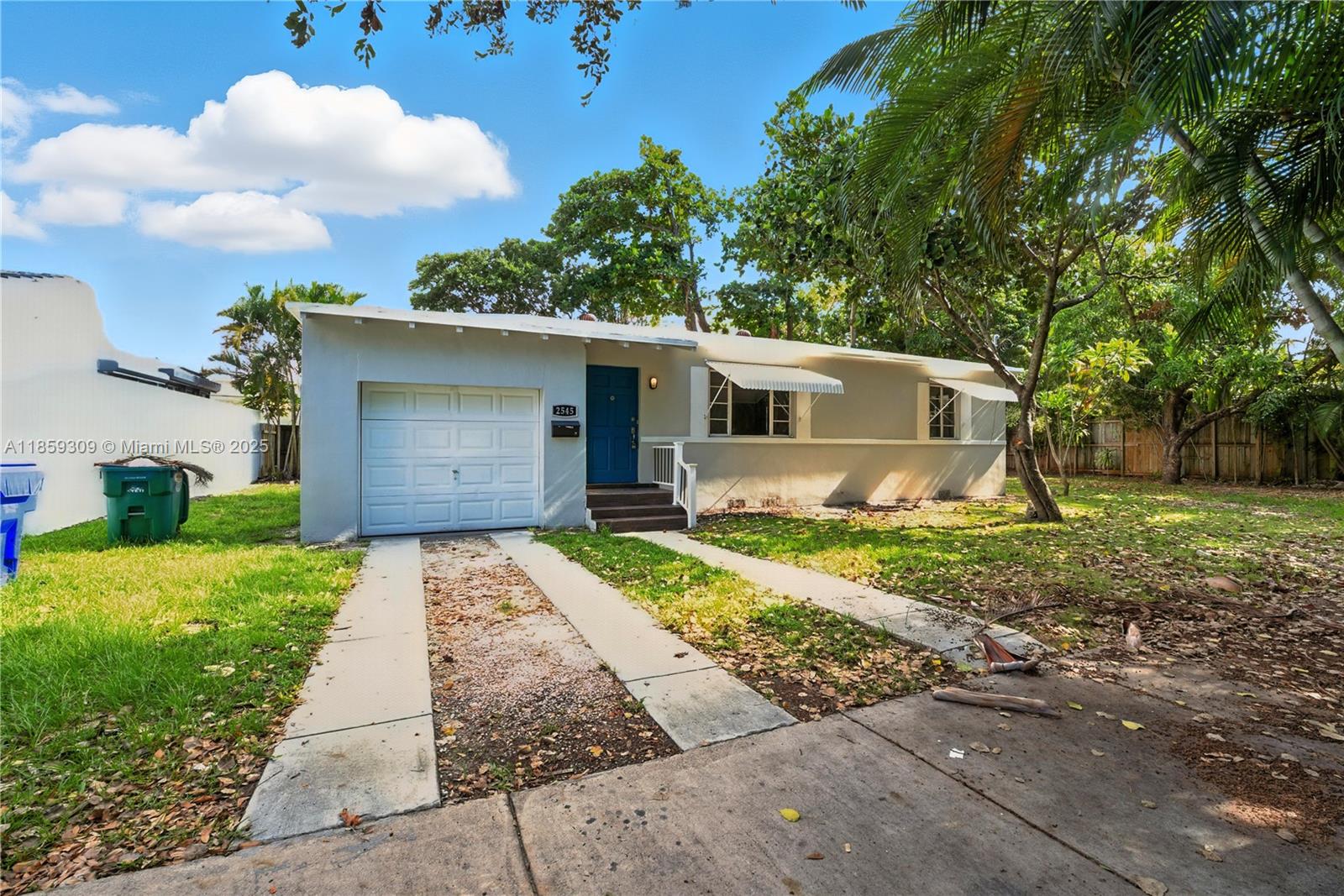 2545 Southwest 27th Lane Miami, FL 33133 - Photo 3 of 26 a front view of a house with a yard and a garage