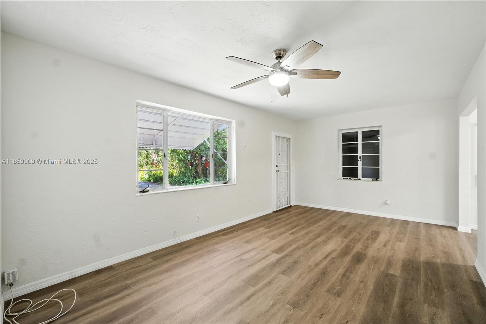 2545 Southwest 27th Lane Miami, FL 33133 - Photo 8 of 26 a view of an empty room with wooden floor and a window