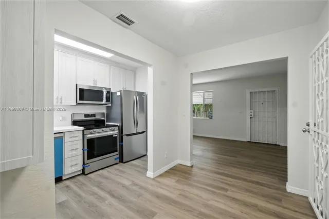 a view of a kitchen with a sink stove refrigerator and microwave