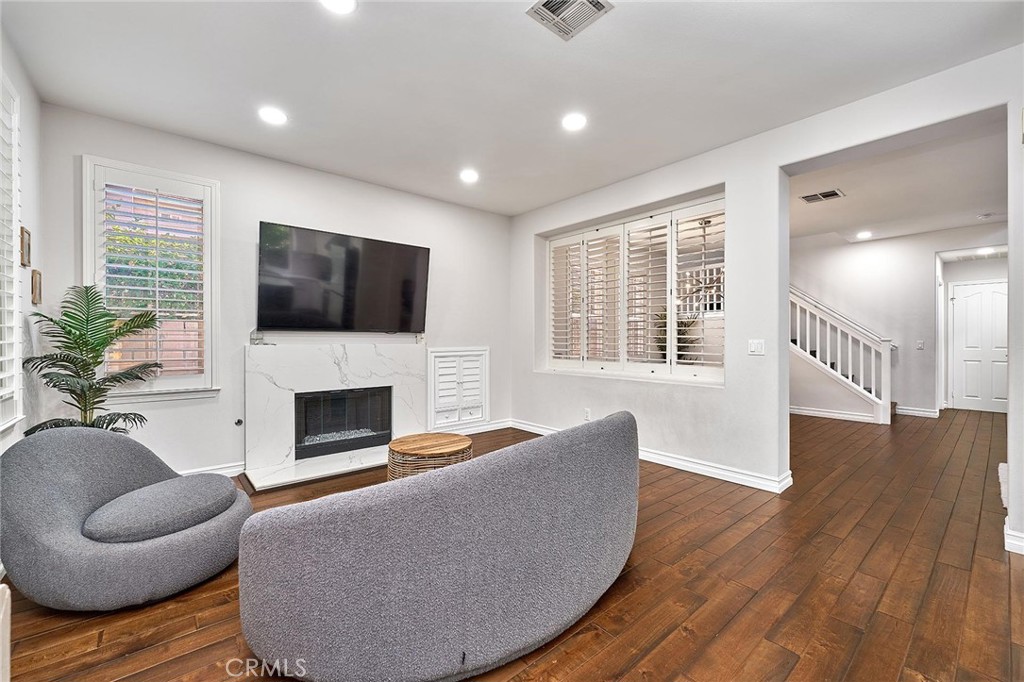 25553 Fitzgerald Avenue Stevenson Ranch, CA 91381 - Photo 13 of 40 a living room with furniture a flat screen tv and a fireplace