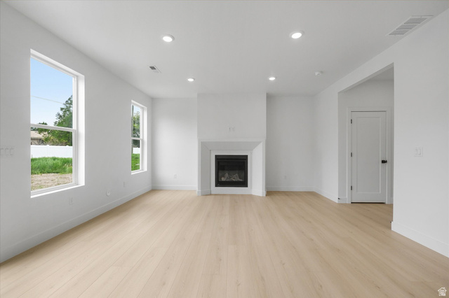 844 North 400 West Logan, UT 84321 - Photo 5 of 43 Bright interior featuring wood-finish flooring, a contemporary fireplace with a white mantel, recessed lighting, and large windows