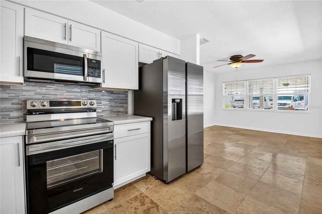 13440 1st Street East Madeira Beach, FL 33708 - Photo 15 of 44 a kitchen with stainless steel appliances a stove a microwave and a refrigerator