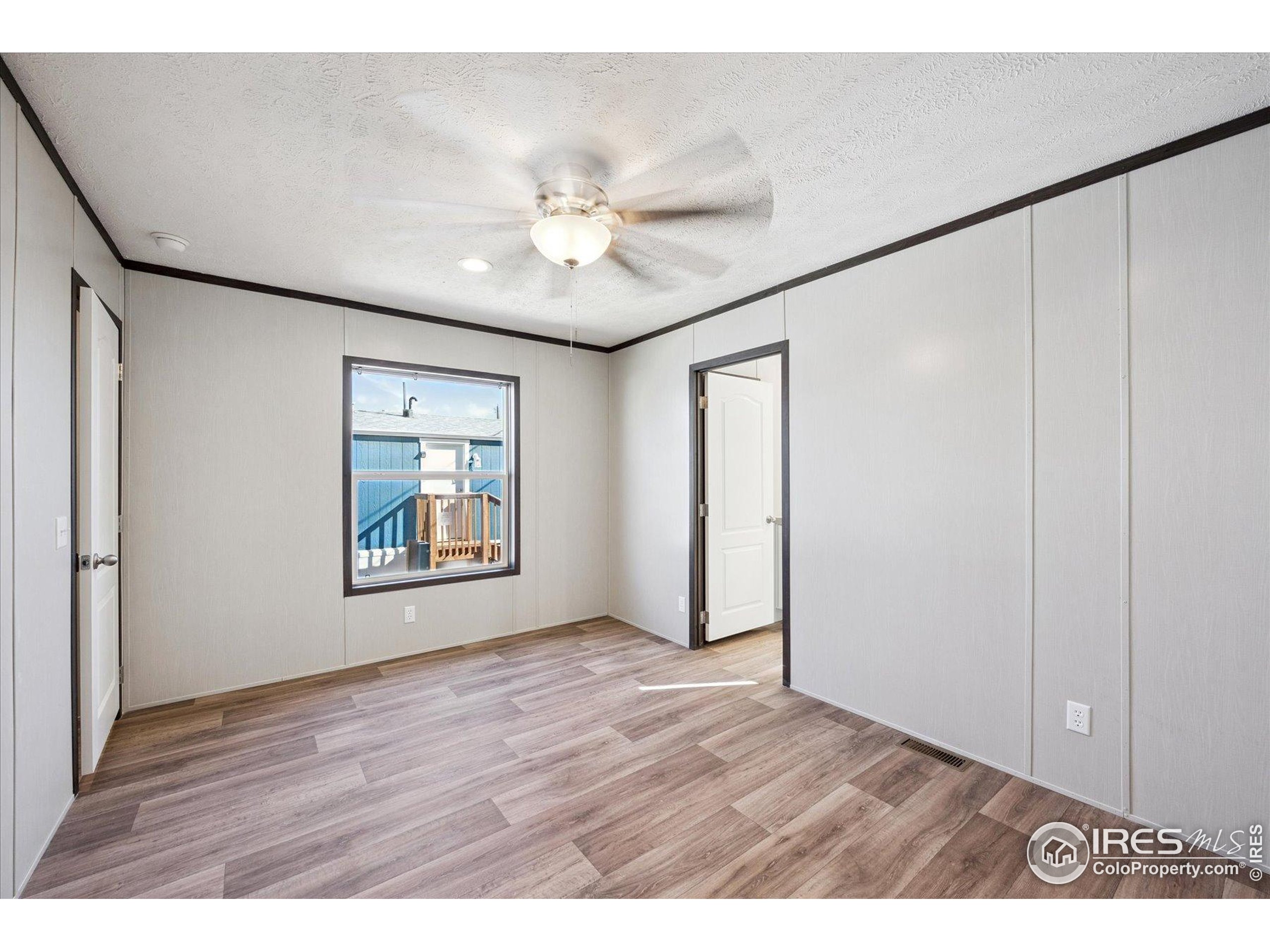 830 1st Street, Unit 2 Pierce, CO 80650 - Photo 11 of 16 a view of an empty room with a window and wooden floor