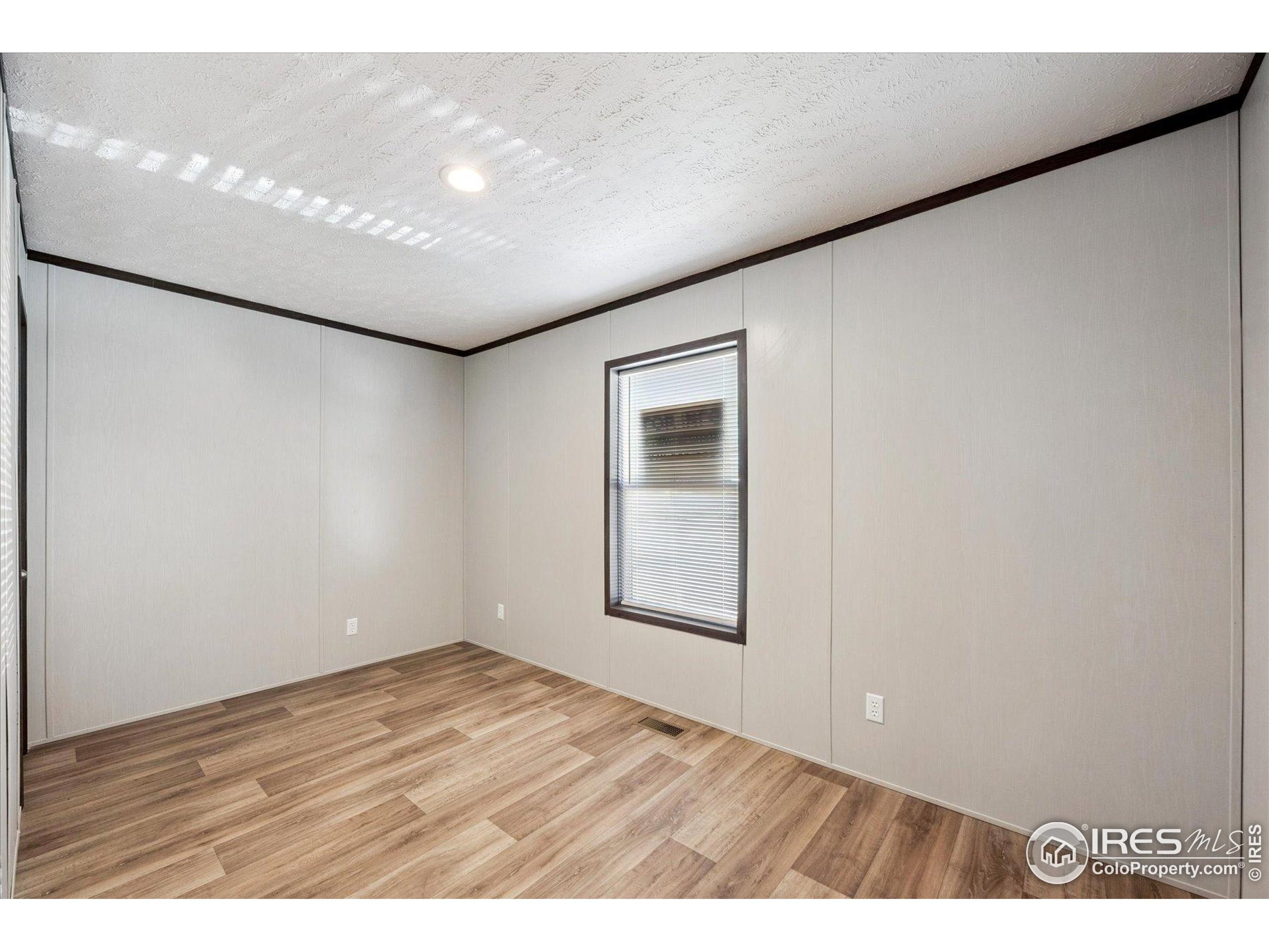 830 1st Street, Unit 2 Pierce, CO 80650 - Photo 13 of 16 a view of an empty room with wooden floor and a window
