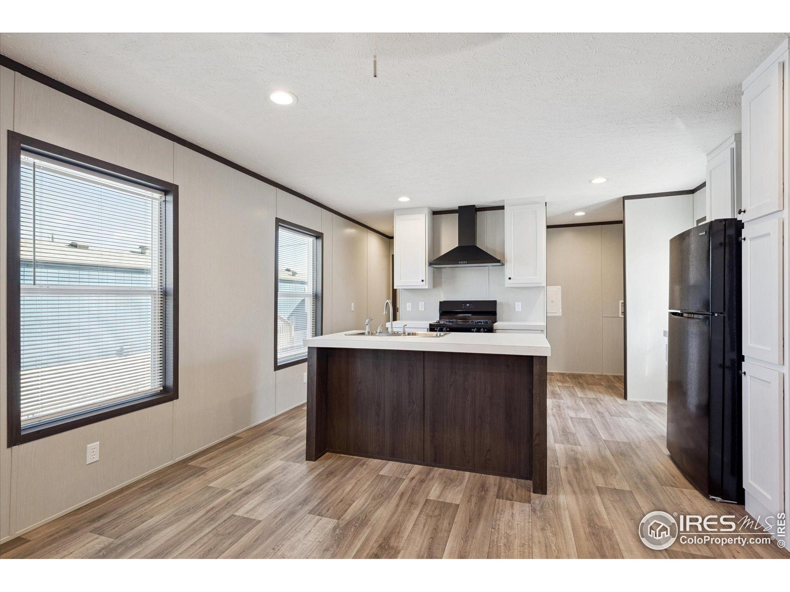 830 1st Street, Unit 2 Pierce, CO 80650 - Photo 7 of 16 a kitchen with stainless steel appliances granite countertop a refrigerator a sink and wooden cabinets