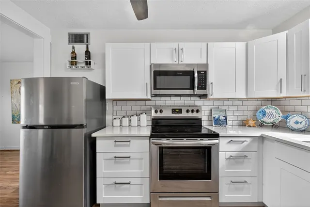 a kitchen with refrigerator a microwave a stove and cabinets