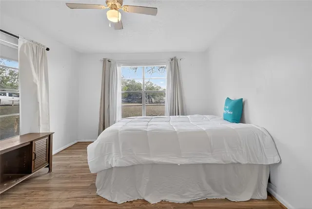 a bedroom with a bed and wooden floor