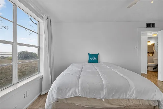 a bedroom with a bed and a large window