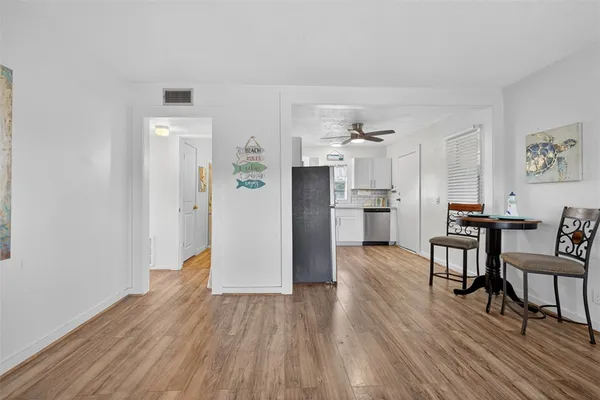 a view of kitchen with refrigerator microwave and wooden floor