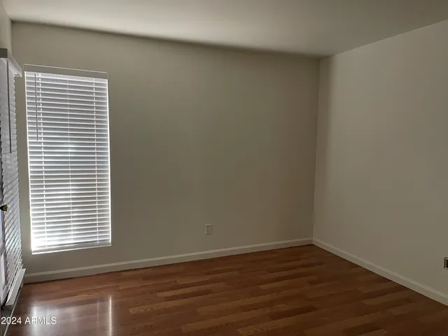 a view of a small space with wooden floor and a window